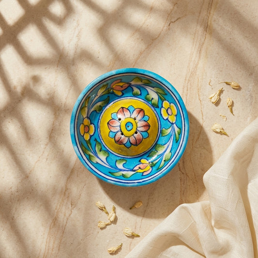 Hand-painted Blue Pottery round incense stand in dappled light, full turquoise and yellow motif visible