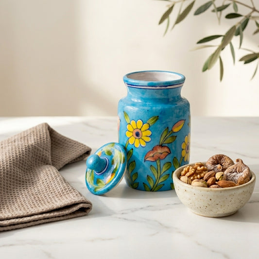 Blue Pottery ceramic jar used as a dry storage container, lid off, nuts displayed in a bowl alongside