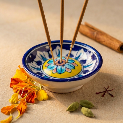 Blue Pottery incense holder in a festive puja decor with marigold petals and star anise