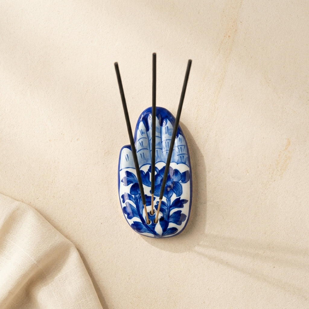 Jaipur Blue Pottery palm incense holder from above showing full cobalt floral vine surface, sticks arranged