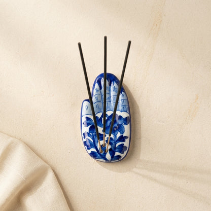 Jaipur Blue Pottery palm incense holder from above showing full cobalt floral vine surface, sticks arranged